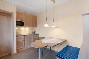 a small kitchen with a wooden table and a table and chairs at Pension Jürgens Zimmer in Attendorn