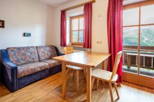 a living room with a table and a couch at Lindenhof Apt 2 in Vandoies