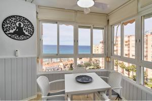 een kamer met ramen en een tafel en stoelen bij Apartamento Sol y Playa A83 in Torrox