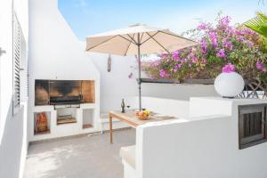 a patio with a table and an umbrella at La Lujancita in Puerto del Carmen
