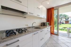 eine Küche mit weißen Schränken und einem Herd mit Backofen in der Unterkunft Appartamento Lago Blu in Manerba del Garda