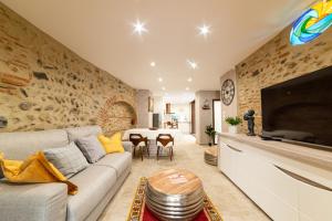 een woonkamer met een bank en een tafel bij Plaisir des pierres in Rivesaltes