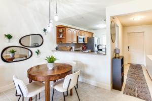 a kitchen and dining room with a table and chairs at Golf Getaway Cape Coral Condo 1 Mi to River! in Cape Coral Hospital Heliport