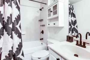 a white bathroom with a toilet and a sink at Golf Getaway Cape Coral Condo 1 Mi to River! in Cape Coral Hospital Heliport +16 photos