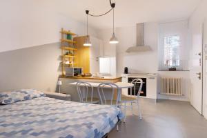 アッバディーア・ラリアーナにあるLa filandaのベッドとテーブルと椅子のある寝室