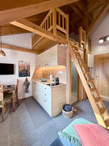 un lit mezzanine dans une chambre avec un lavabo et un bureau dans l'établissement apartmány V Lese, à Bedřichov