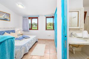 a bedroom with a bed and a sink and a bathroom at Blue House Laconia in Cannigione