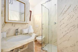 a bathroom with a sink and a glass shower at Blue House Laconia in Cannigione +15 photos