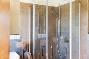 a shower with a glass door in a bathroom at Ferienwohnung Elfriede in Neukirch +23 photos