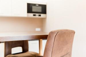 a chair in front of a desk with a television at Ferienwohnung Elfriede in Neukirch