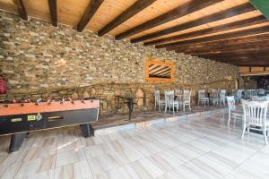 a room with a stone wall with a pool table and chairs at Mirage Arillas Apartment C in Arillas