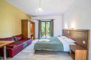 a living room with a bed and a couch at Mirage Arillas Studio Type C16 in Arillas