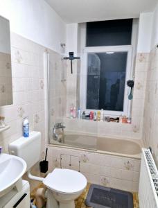 ein Badezimmer mit Toilette, Badewanne und Waschbecken in der Unterkunft CityNest hannover S4 in Hannover + 12 Fotos