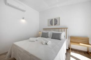 une chambre blanche avec un lit avec des serviettes dessus dans l'établissement Old Town Apartments Sea View, à Lagos