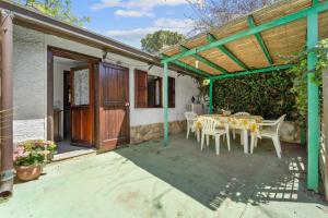 a patio with a table and chairs under a pergola at The Loft of Stars in Torre delle Stelle +14 photos
