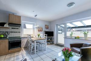 a kitchen and living room with a table and chairs at Ferienhaus Kikki in Friedrichskoog-Spitz +17 photos