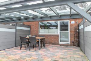 a patio with a table and chairs on a brick wall at Ferienhaus Kikki in Friedrichskoog-Spitz