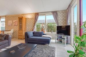 a living room with a couch and a tv at Ferienhaus Petten aan Zee in Petten