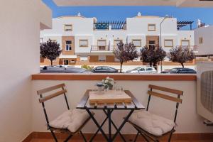 a table and chairs on a balcony with a building at Quinta Gomeira 59 in Tavira