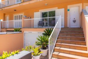 a house with stairs and plants in front of it at Eulalia Beach in Can Picafort