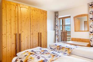 a bedroom with two beds and a wooden wall at Hänsel und Gretel Schlosshof in Umes