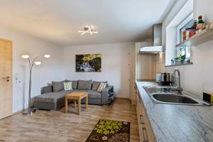 a kitchen and a living room with a couch at Ferienwohnung Alpenblick in Zwiefalten +13 photos