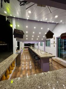 een restaurant met een lange bar met tafels en stoelen bij Pousada Linda Vista in Domingos Martins +63 foto's