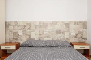 a bedroom with a bed with two nightstands and two tables at Residence Orizzonti app n 3 in Golfo Aranci