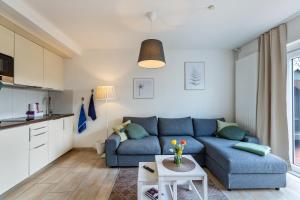 a living room with a blue couch and a table at Gartenglückchen in Lindhöft