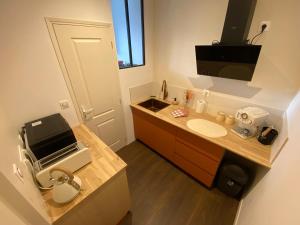 a bathroom with a sink and a television in it at Le Cocon Diamant Jacuzzi & Sauna in Compiègne