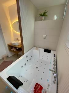 a bathroom with a white tub and a sink at Cocon Diamant - Nuit Romantique - Jacuzzi et Sauna - Hyper-Centre in Compiègne +51 photos