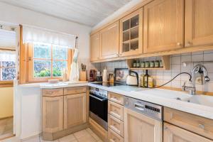 a kitchen with wooden cabinets and a sink at Uriges Landhäuschen in Siegsdorf +20 photos
