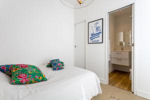 a bedroom with a white bed with two pillows on it at Studio Duplex Au Cœur De Bénodet in Bénodet