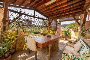 une terrasse avec une table en bois et quelques plantes dans l'établissement Monolocale Il Girasole, à Villaputzu