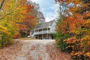 a house on a road in the woods at Pet-Friendly Home with Hot Tub Near Cranmore! in Conway