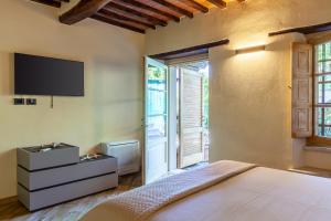 een slaapkamer met een bed en een televisie aan de muur bij La Casa di Kati in Pietrasanta