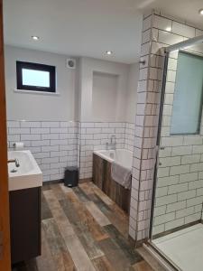 a bathroom with a tub and a sink and a shower at Ridge And Furrow Lodge in Babcary +28 photos