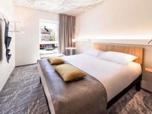 Cette chambre comprend un grand lit avec des oreillers. dans l'établissement ibis Tallinn Center, à Tallinn 142 autres photos