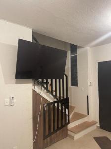 une télévision à écran plat suspendue sur un mur à côté d'un escalier. dans l'établissement Your house in Acapulco Diamante with a Beach Club, à Acapulco