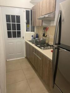 une cuisine avec une cuisinière et un réfrigérateur dans l'établissement Your house in Acapulco Diamante with a Beach Club, à Acapulco