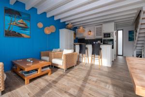 ein Wohnzimmer mit Sofa und Tisch in der Unterkunft La Maison bleue Domainedecolomban in Carnac