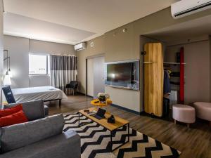 a hotel room with a bed and a living room at ibis Palmas Avenida JK in Palmas
