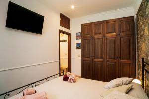 a bedroom with a bed and a tv on the wall at Casa Carly Taormina in Taormina