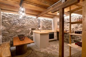a kitchen with a counter and a stone wall at Stieberhof Appartement in Feldthurns