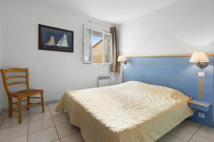 een slaapkamer met een bed, een stoel en een raam bij Appartement Le Plan de La Tour in Plan-de-la-Tour +17 foto's