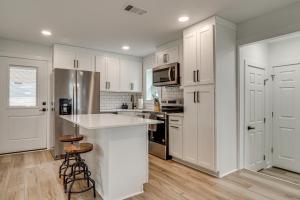 Una cocina con gabinetes blancos y electrodomésticos de acero inoxidable. en Near Historic Georgetown Square! Updated Home, en Georgetown