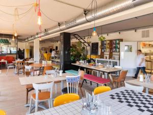 a restaurant with tables and chairs and people walking in the background at greet Hotel Beaune in Beaune