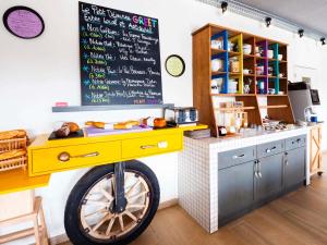 a kitchen with a yellow bike in front of a counter at greet Hotel Beaune in Beaune +153 photos