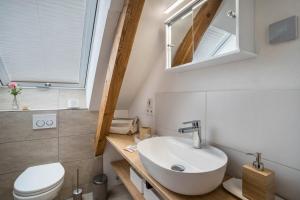 a bathroom with a sink and a toilet and a mirror at Ferienwohnung Annele in Loßburg +13 photos