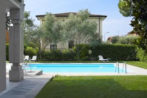 a swimming pool with two chairs and a house at Baseventuno 4 Bilocale in San Martino della Battaglia